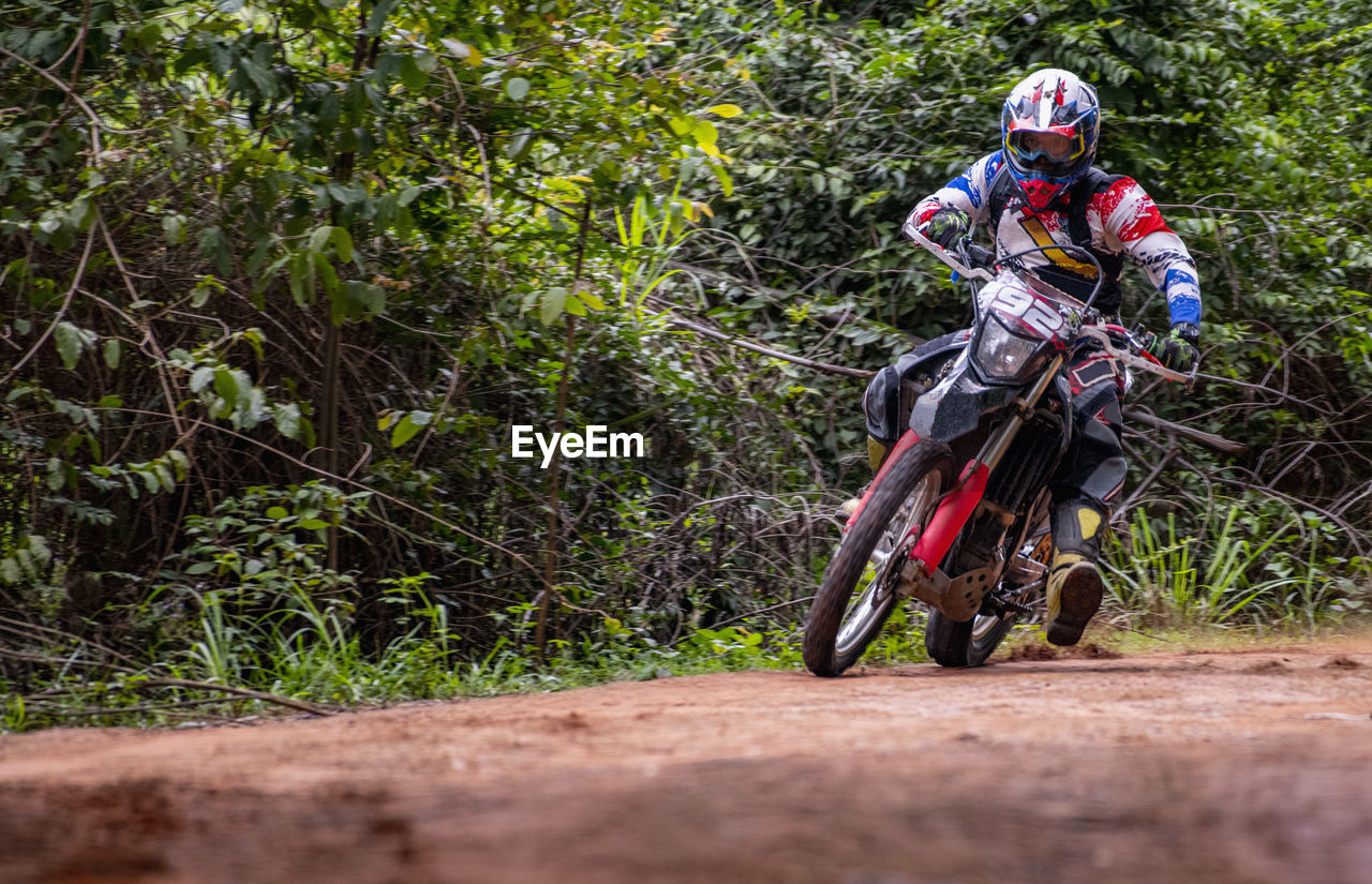 Man speeding his dirt-bike on gravel road in pak chong / thailand