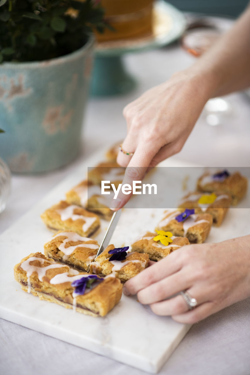 Cropped hands of woman cutting sweet food