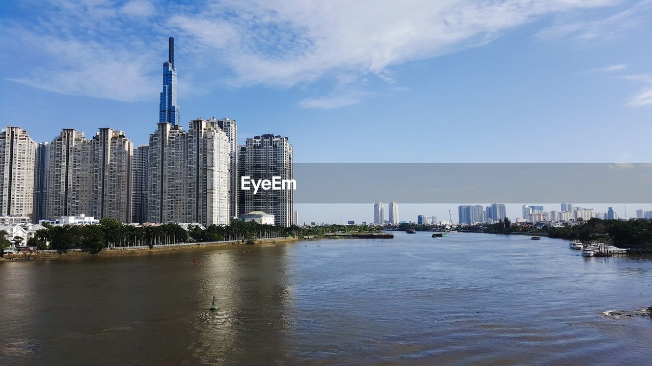 River by buildings against sky in city