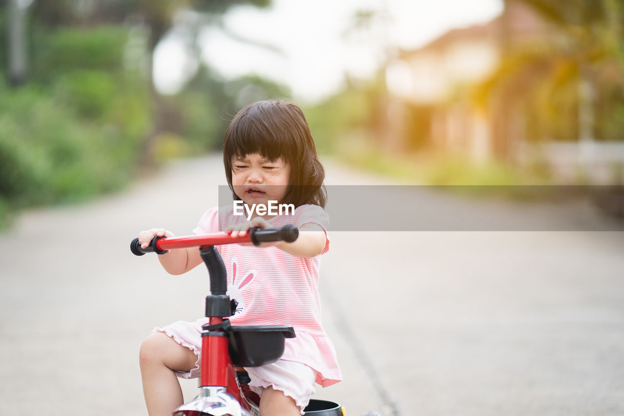 Cute girl riding bicycle on road