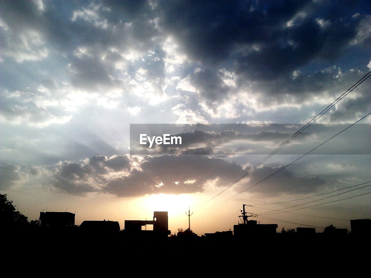 LOW ANGLE VIEW OF BUILDINGS AGAINST CLOUDY SKY AT SUNSET