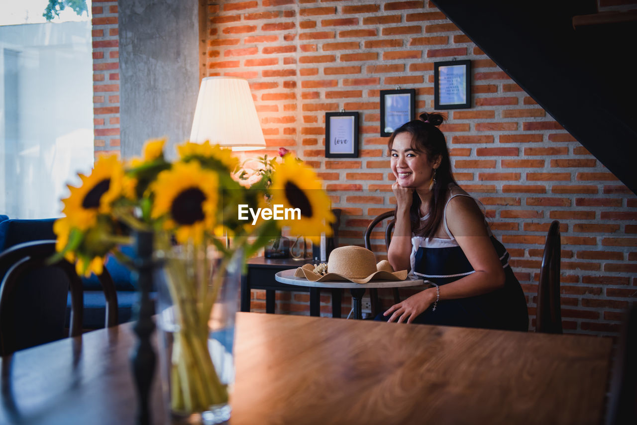 Portrait of smiling woman sitting at table in cafe