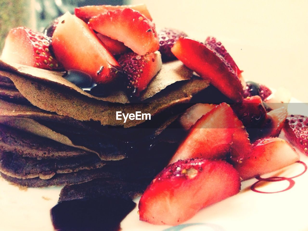 Pancakes topped with chocolate and strawberries