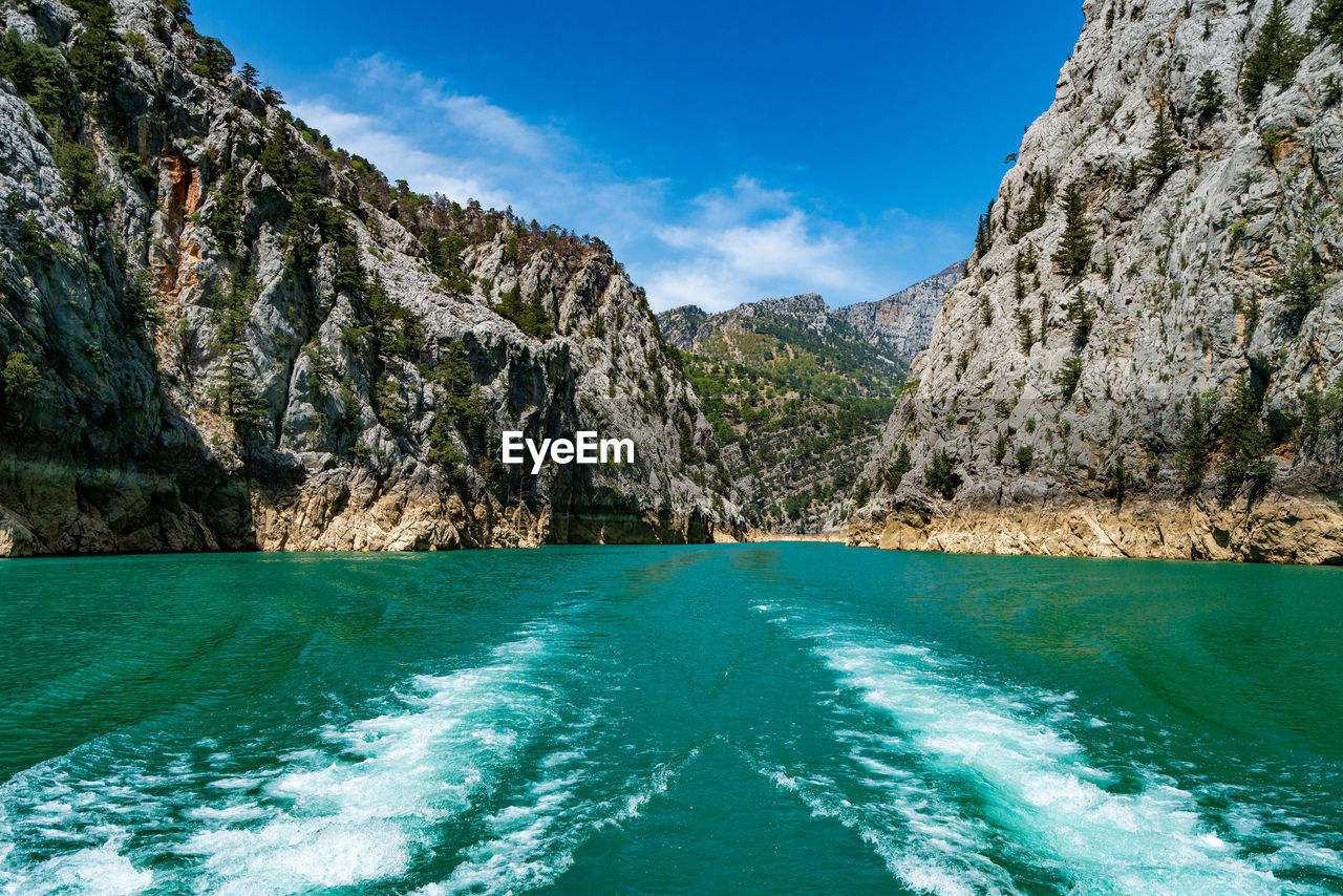 scenic view of lake by mountains against sky