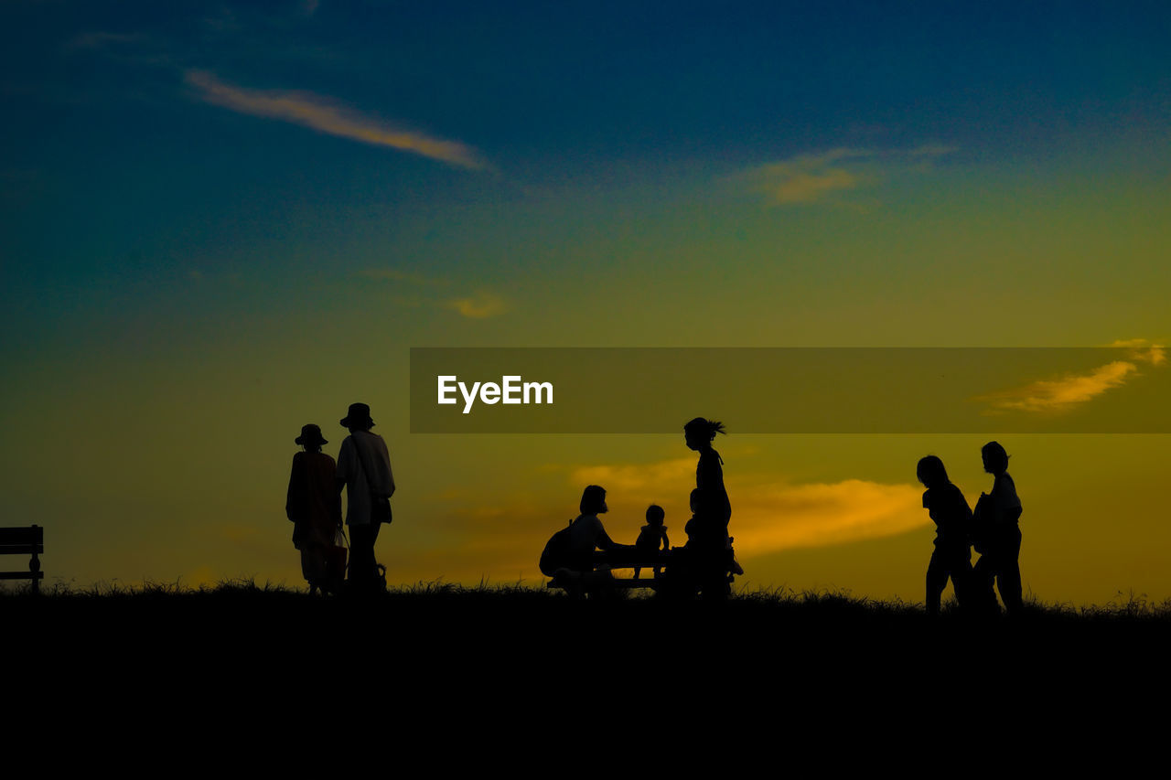 silhouette people on landscape against sky during sunset