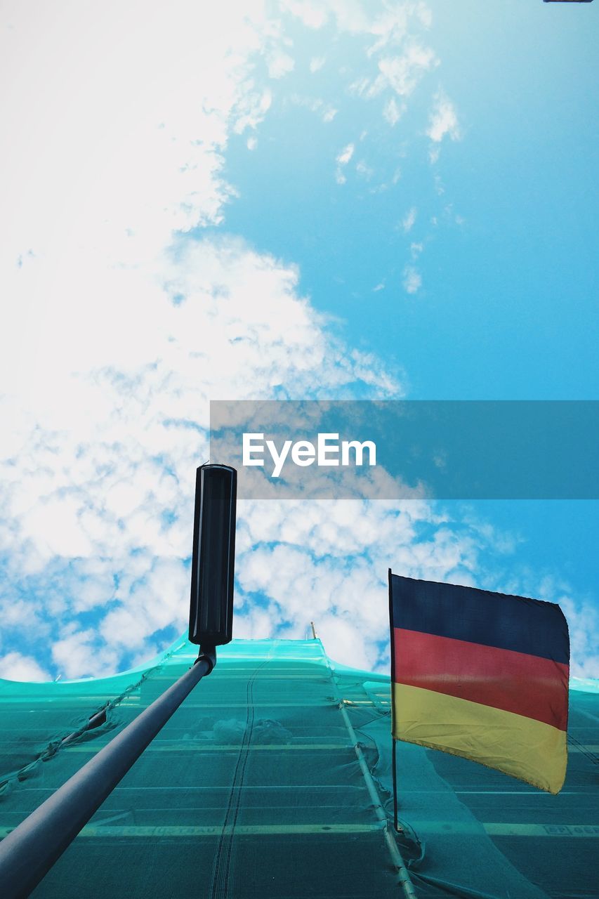 Low angle view of german flag on construction building against sky