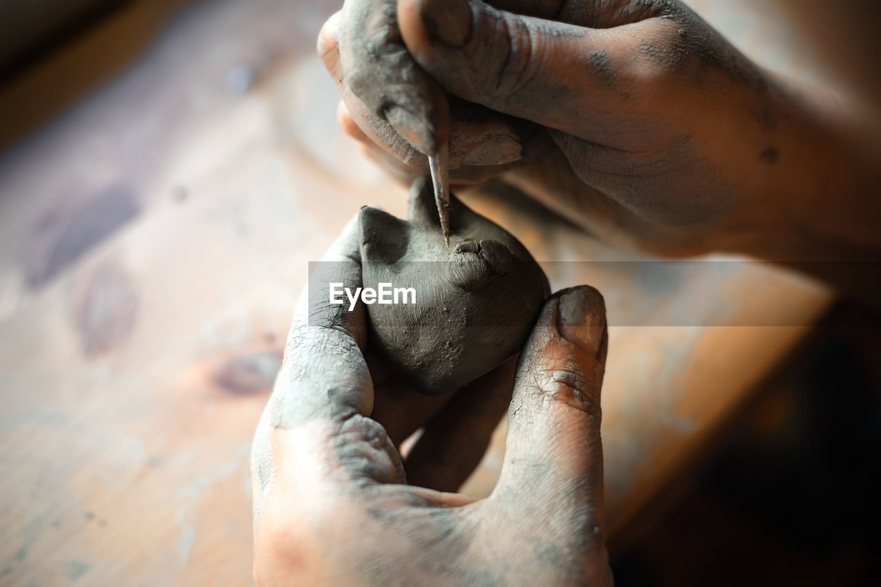 Working hands potter working on small clay cat hobby handmade