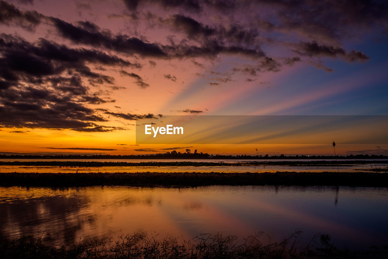 SCENIC VIEW OF LAKE AGAINST SKY AT SUNSET