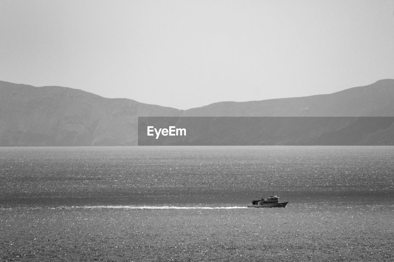 Distant boat sailing on sea