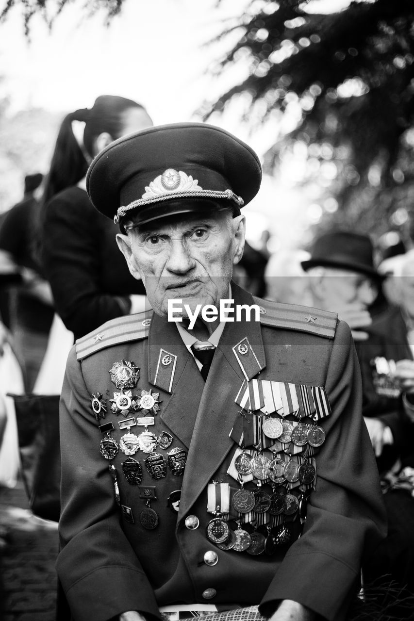 PORTRAIT OF MAN WEARING HAT HOLDING CAMERA