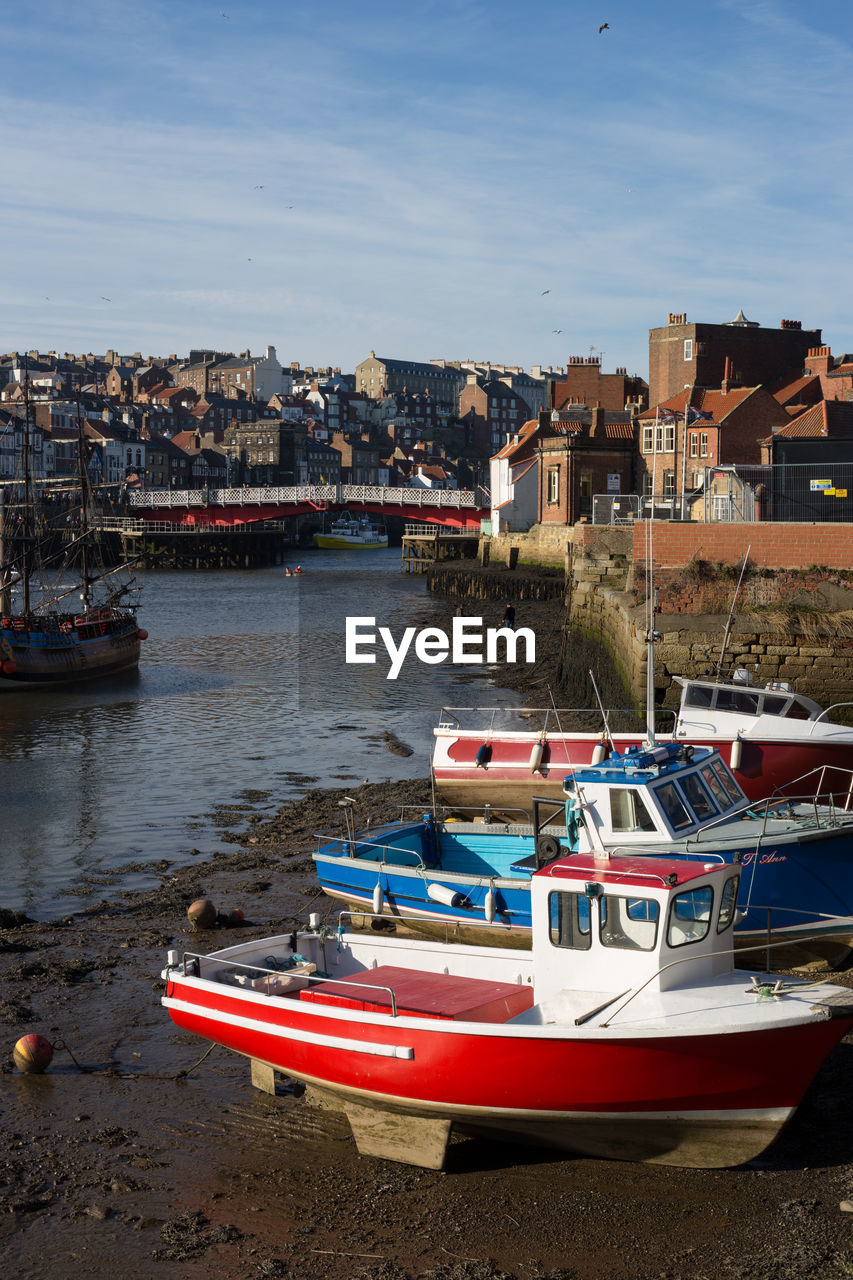 BOATS MOORED ON SEA BY BUILDINGS IN CITY