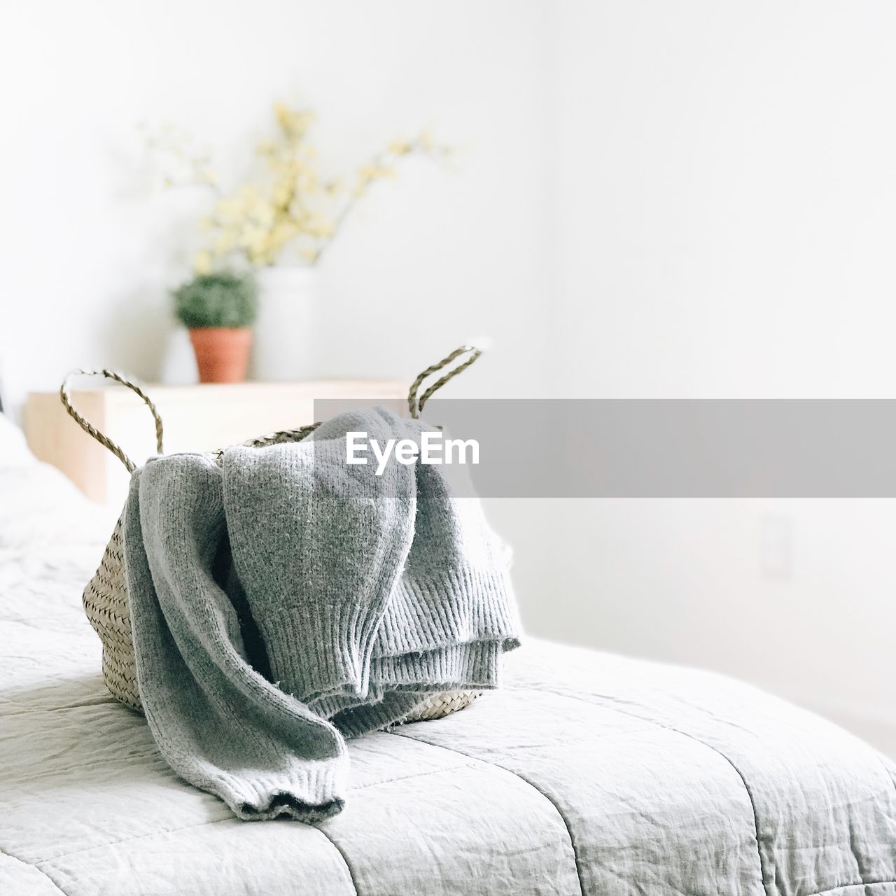 Close-up of sweater in purse on bed at home