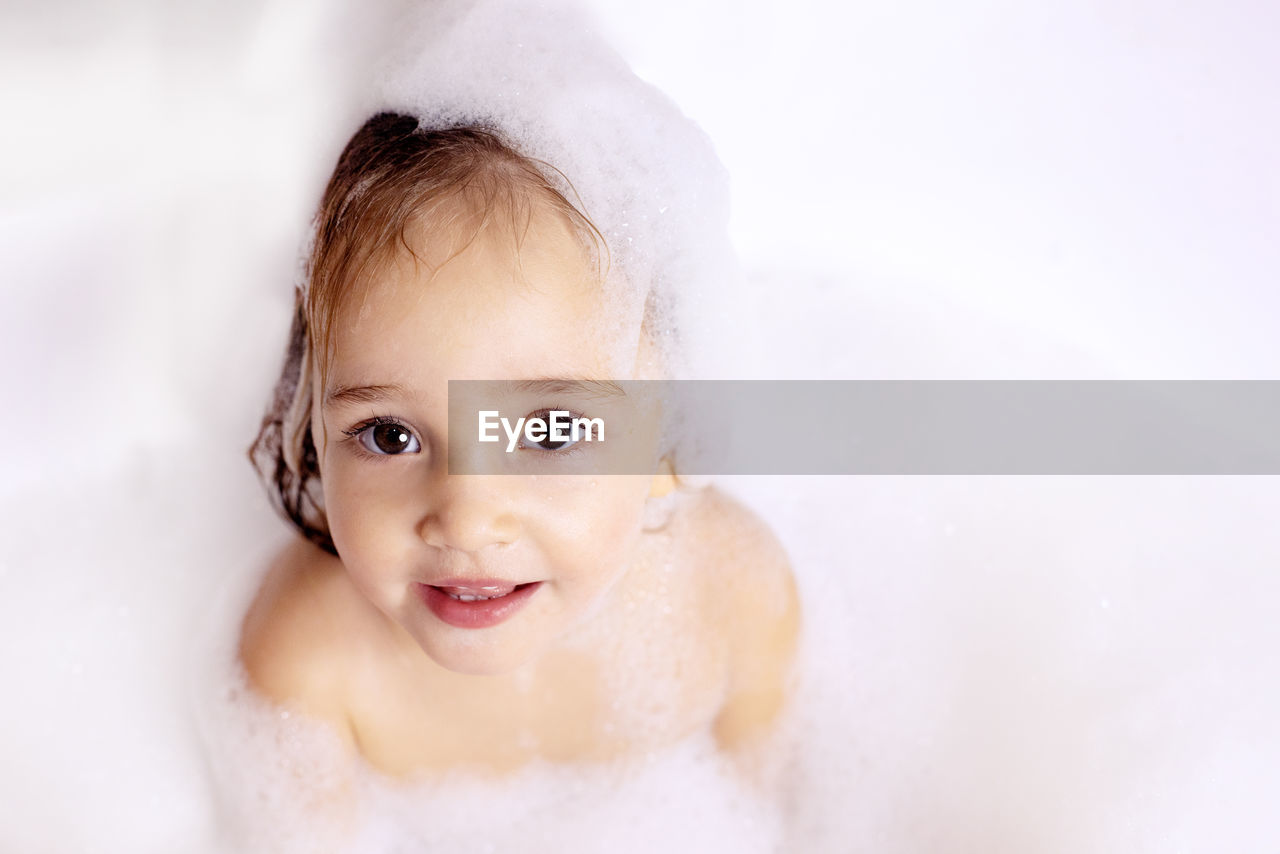 Close-up portrait of girl bathing at bathroom