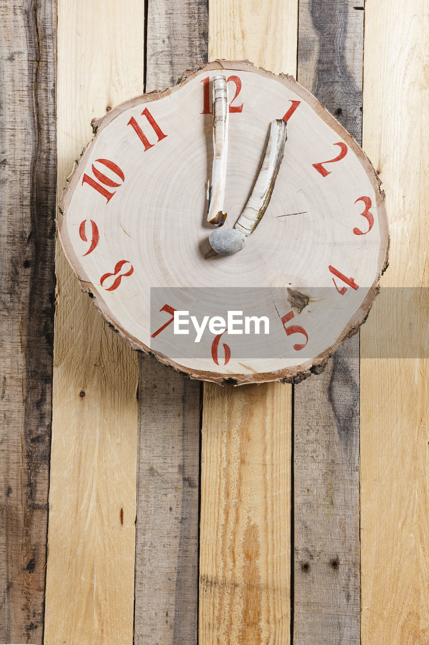 Close-up of clock hanging on wooden wall