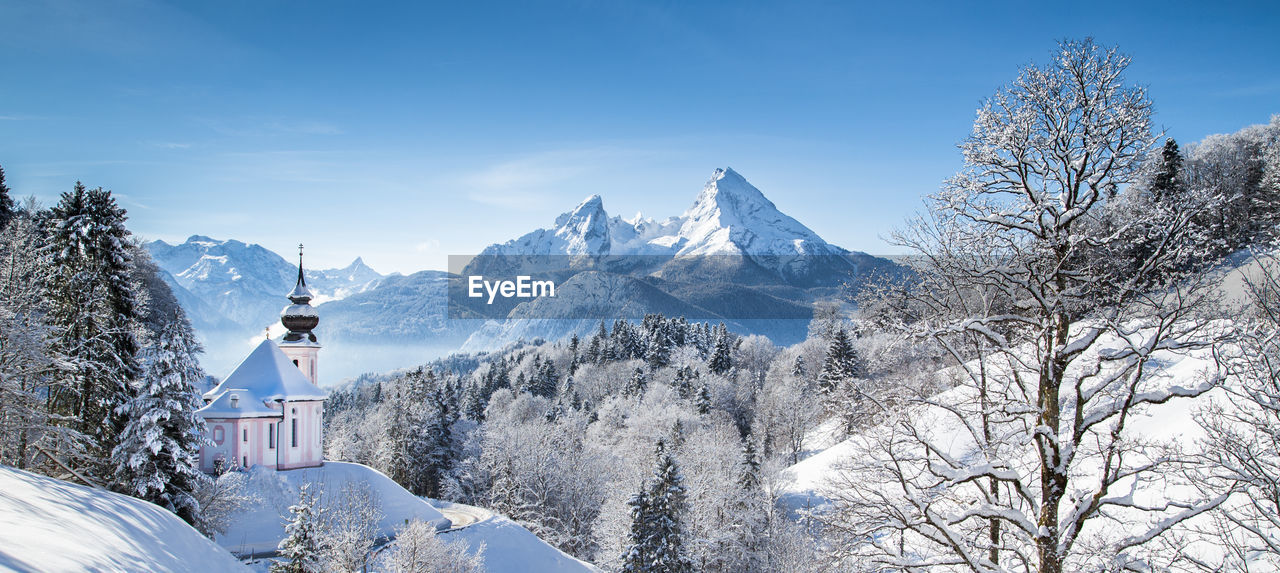 Maria gern church on snowcapped mountains against blue sky