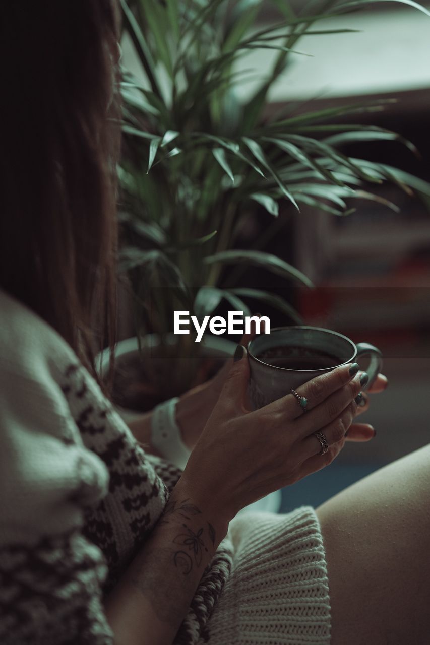 CLOSE-UP OF WOMAN HOLDING COFFEE CUP