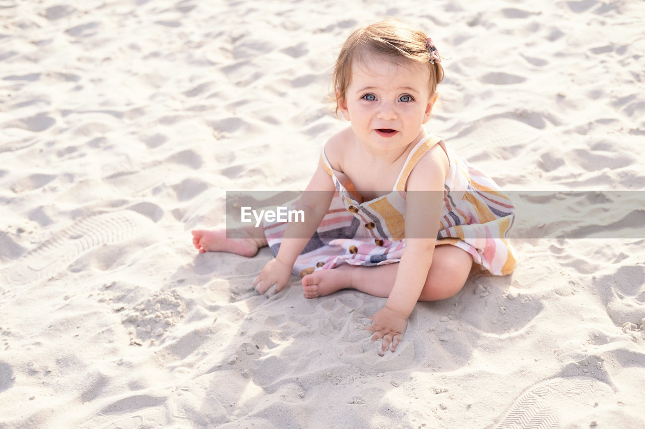 Cute girl playing on sand at beach