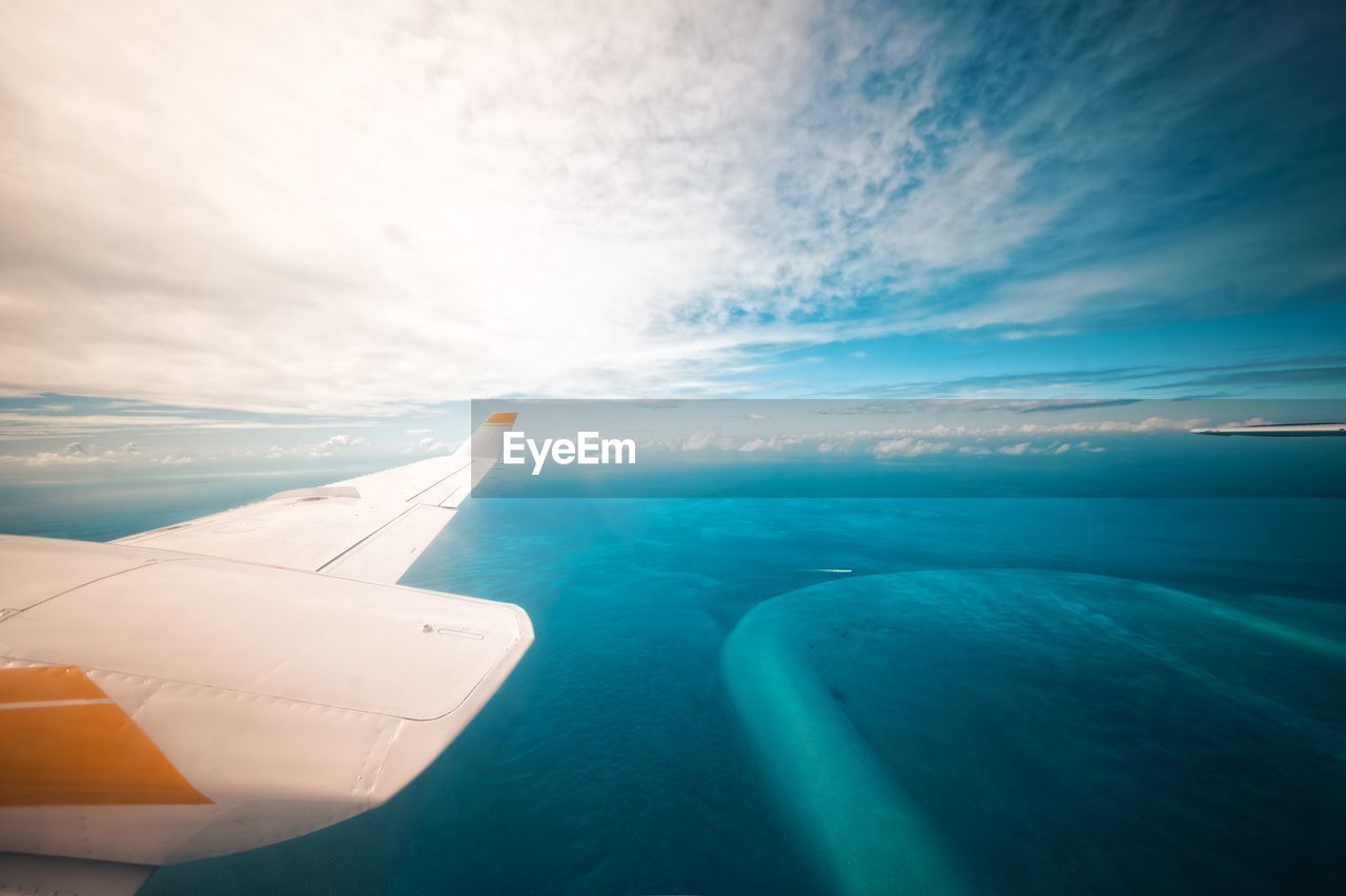 AERIAL VIEW OF SEA AND AIRPLANE AGAINST SKY