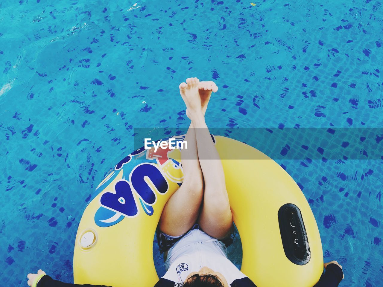 LOW SECTION OF PERSON RELAXING IN POOL