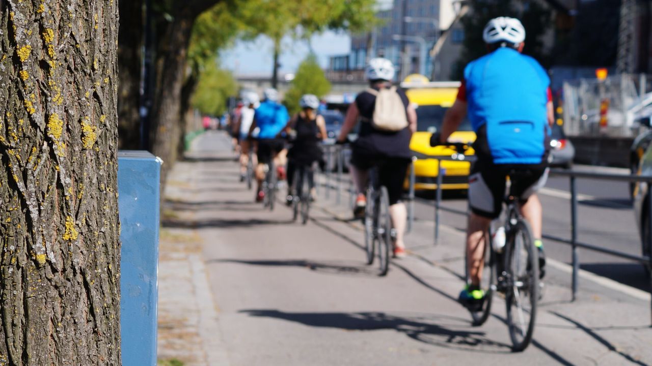 People riding bicycle on sidewalk