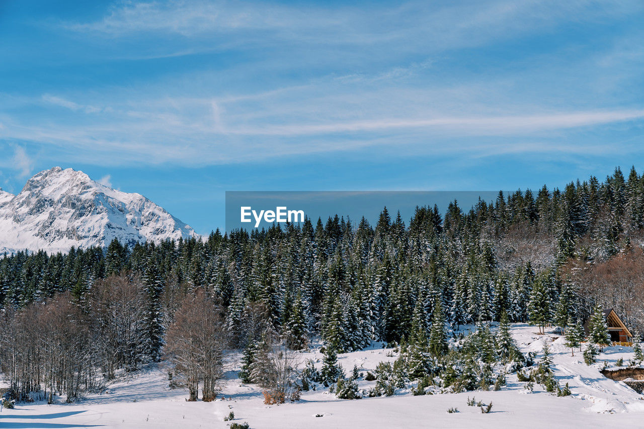 panoramic view of snow covered mountains against blue sky