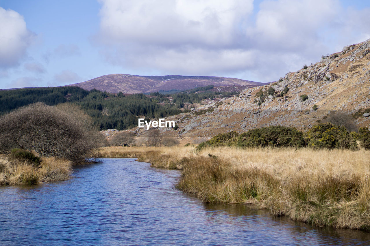 Scenic view of river amidst mountains against sky