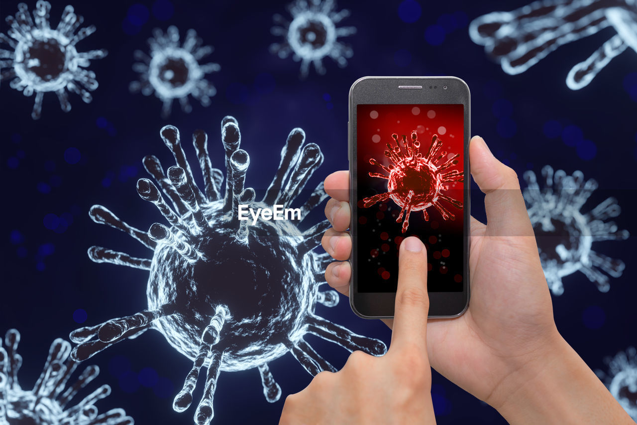 Digital composite image of hands using smart phone against biological cell