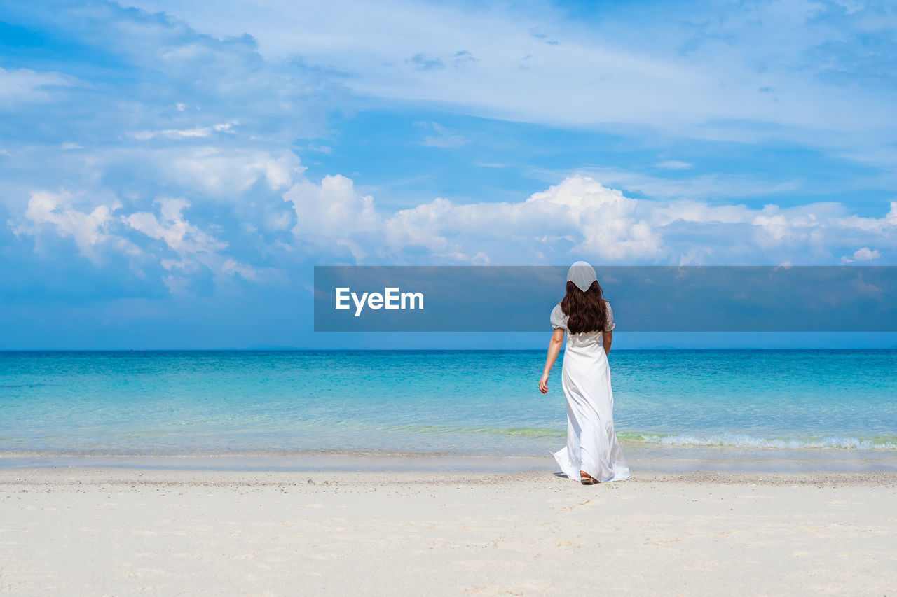 Woman on beach against sky