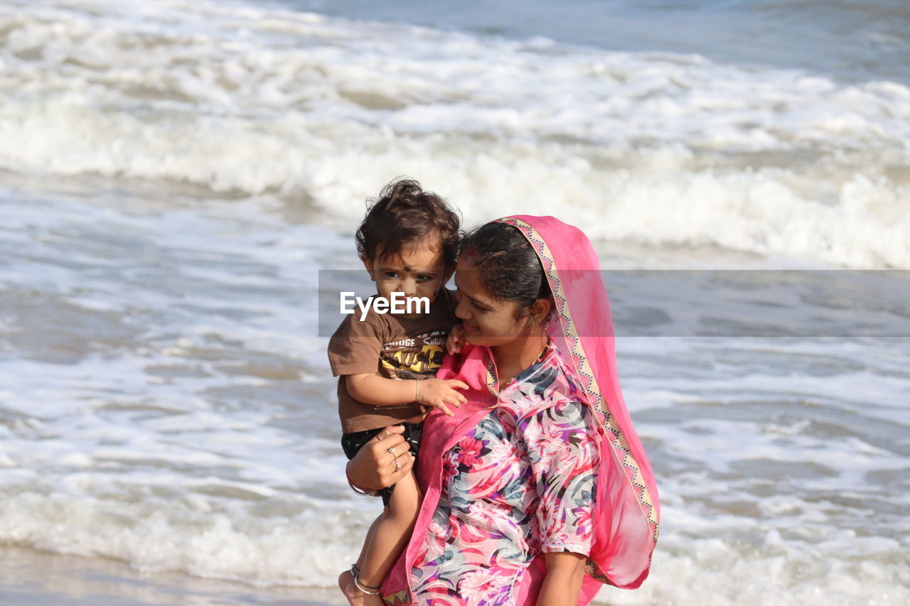 Little one years old boy portraits with mother in summer afternoon on beach chennai, marina beach