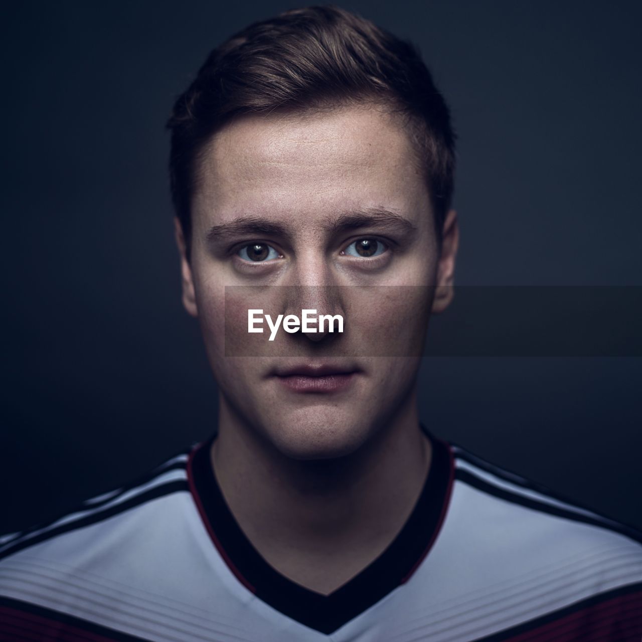 Close-up portrait of young man against black background