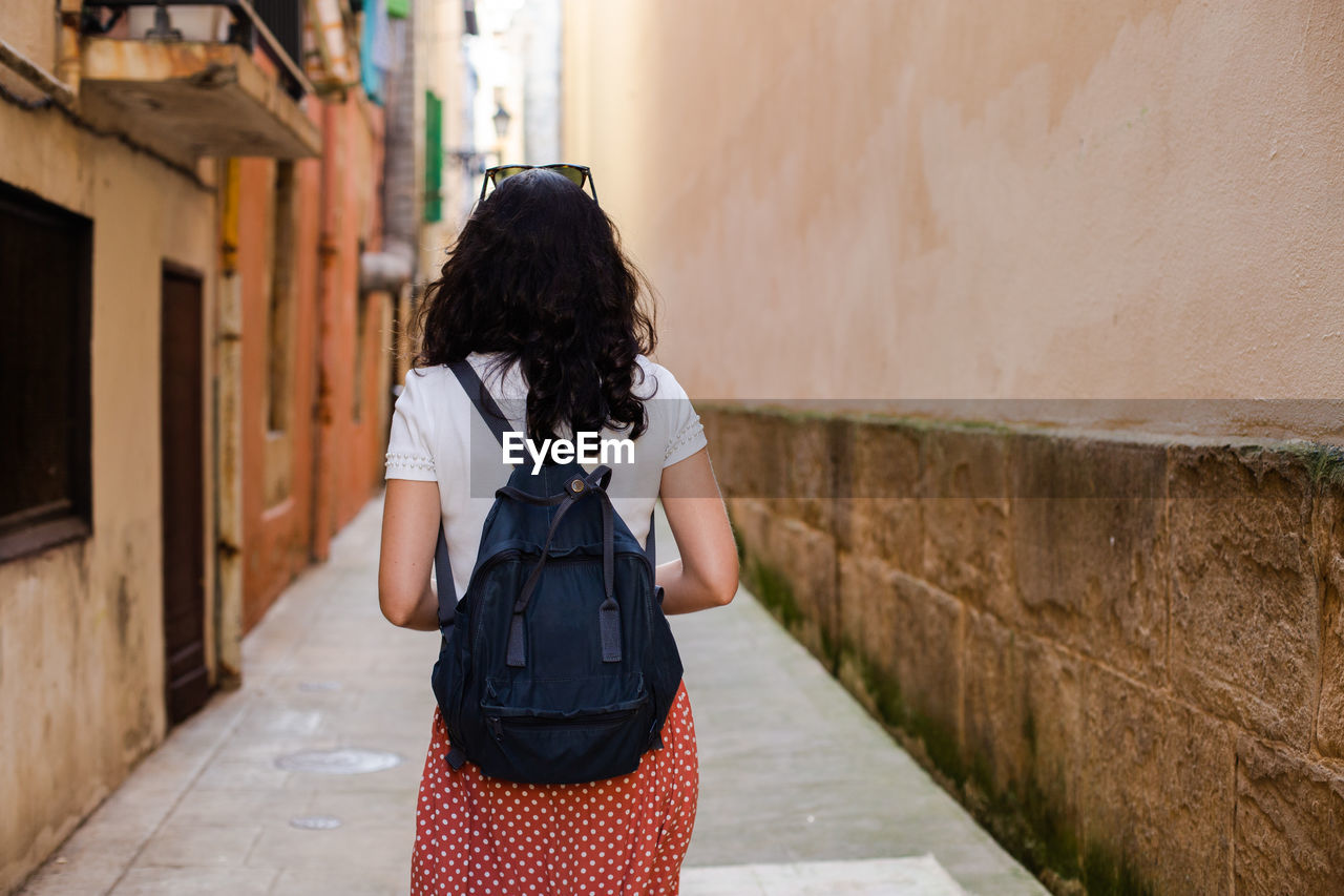 Rear view of woman standing on wall