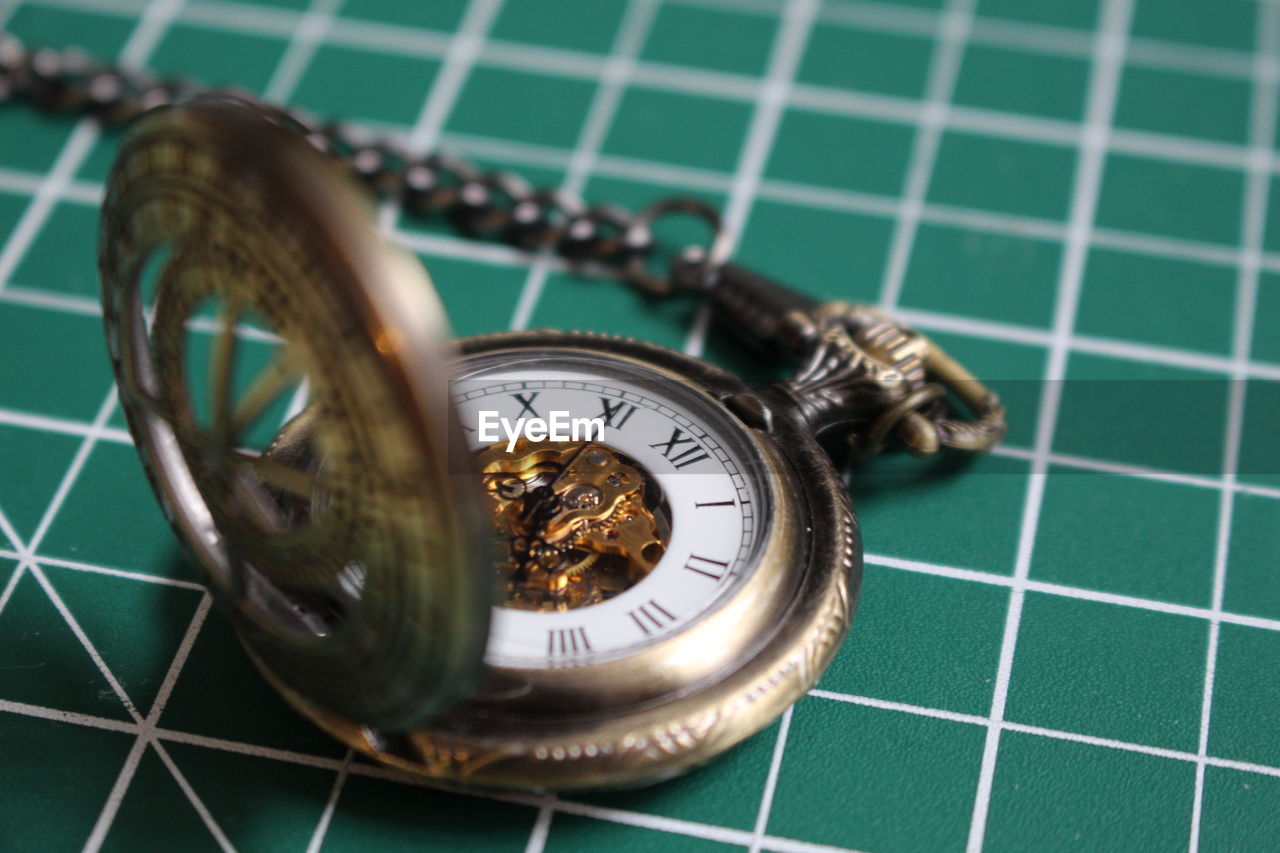 Close-up of pocket watch on cutting mat