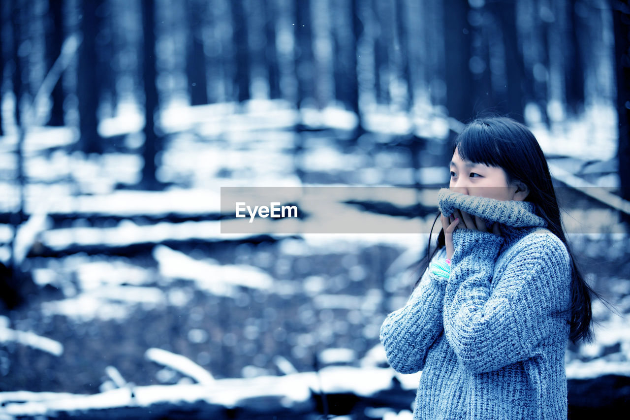 Woman in snow covered forest