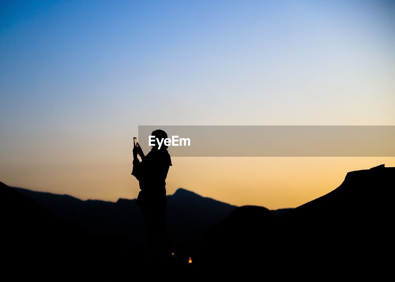 SILHOUETTE MAN STANDING AGAINST SKY DURING SUNSET