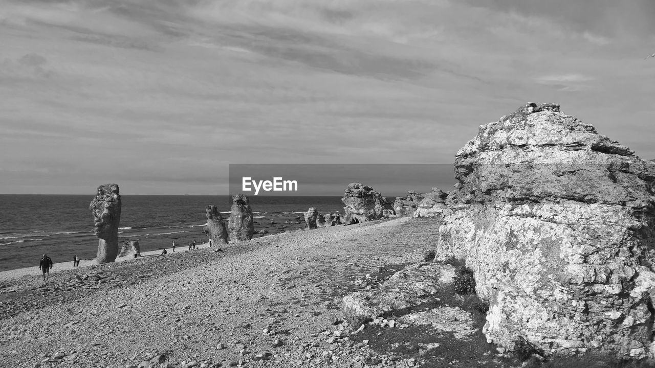 Scenic view of beach against cloudy sky