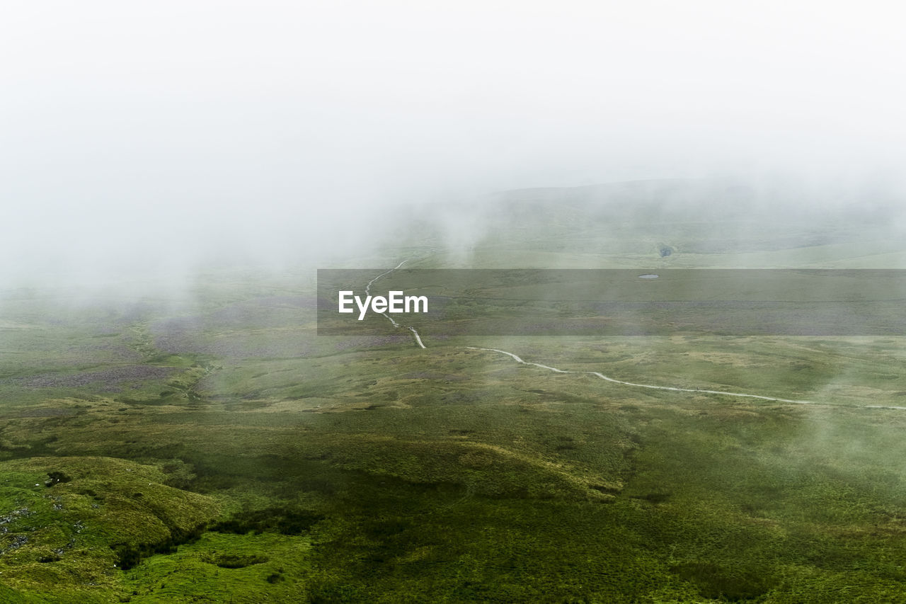 Scenic view of landscape against sky during foggy weather