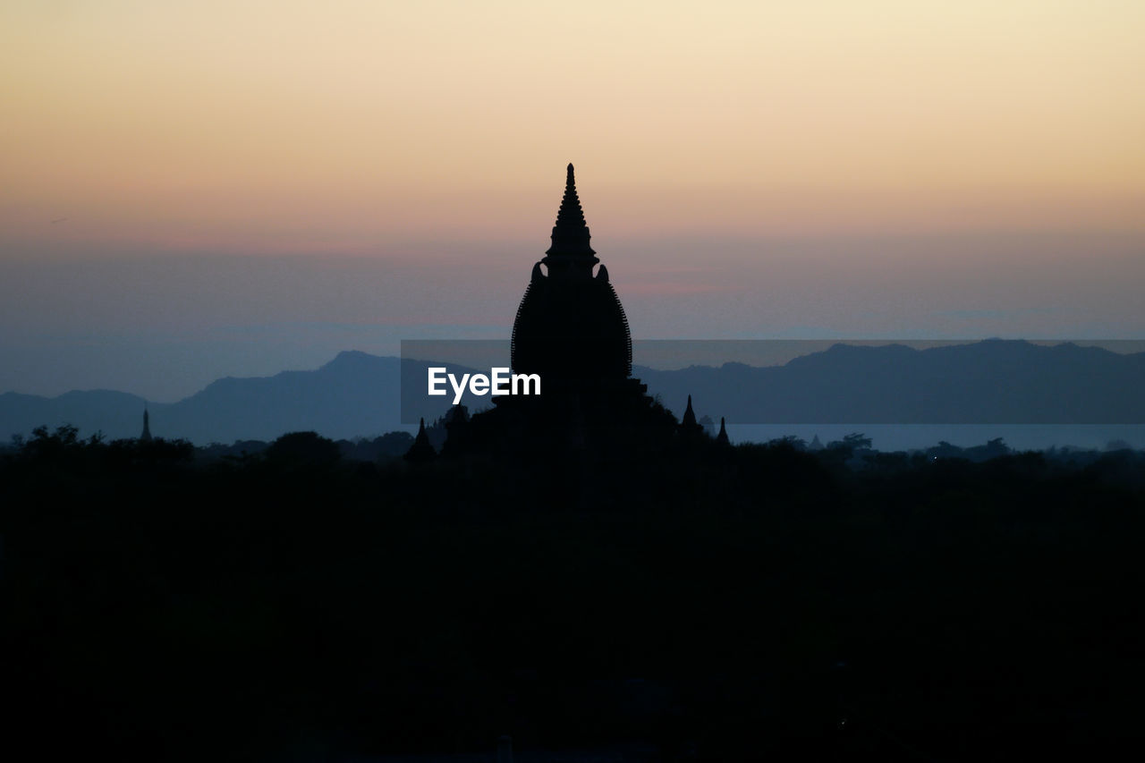 Silhouette of pagoda against sky during sunset