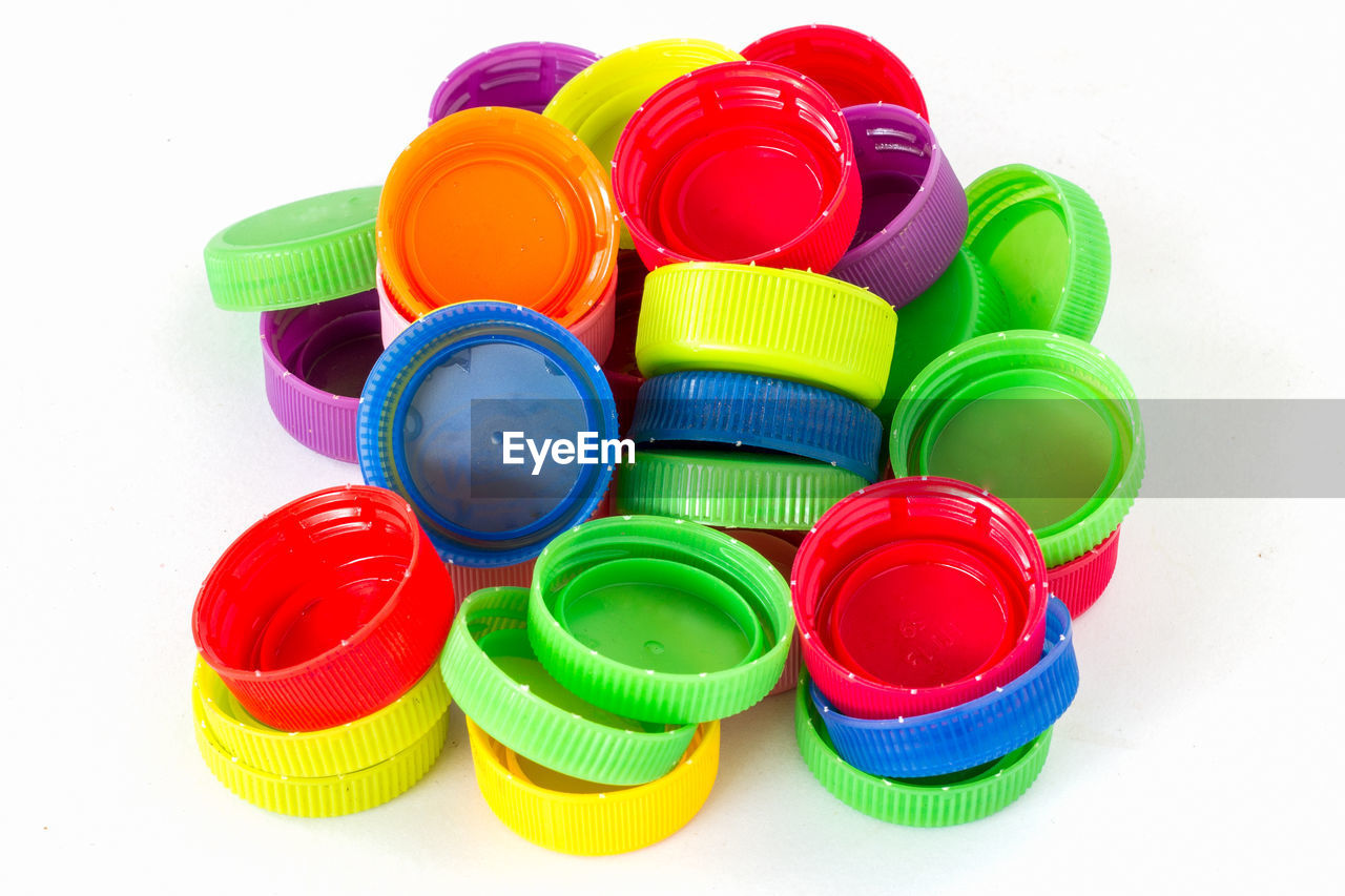 HIGH ANGLE VIEW OF MULTI COLORED TOYS ON WHITE BACKGROUND