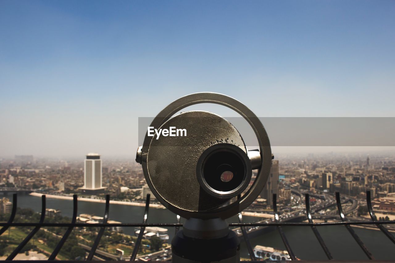 CLOSE-UP OF COIN-OPERATED BINOCULARS AGAINST SKY