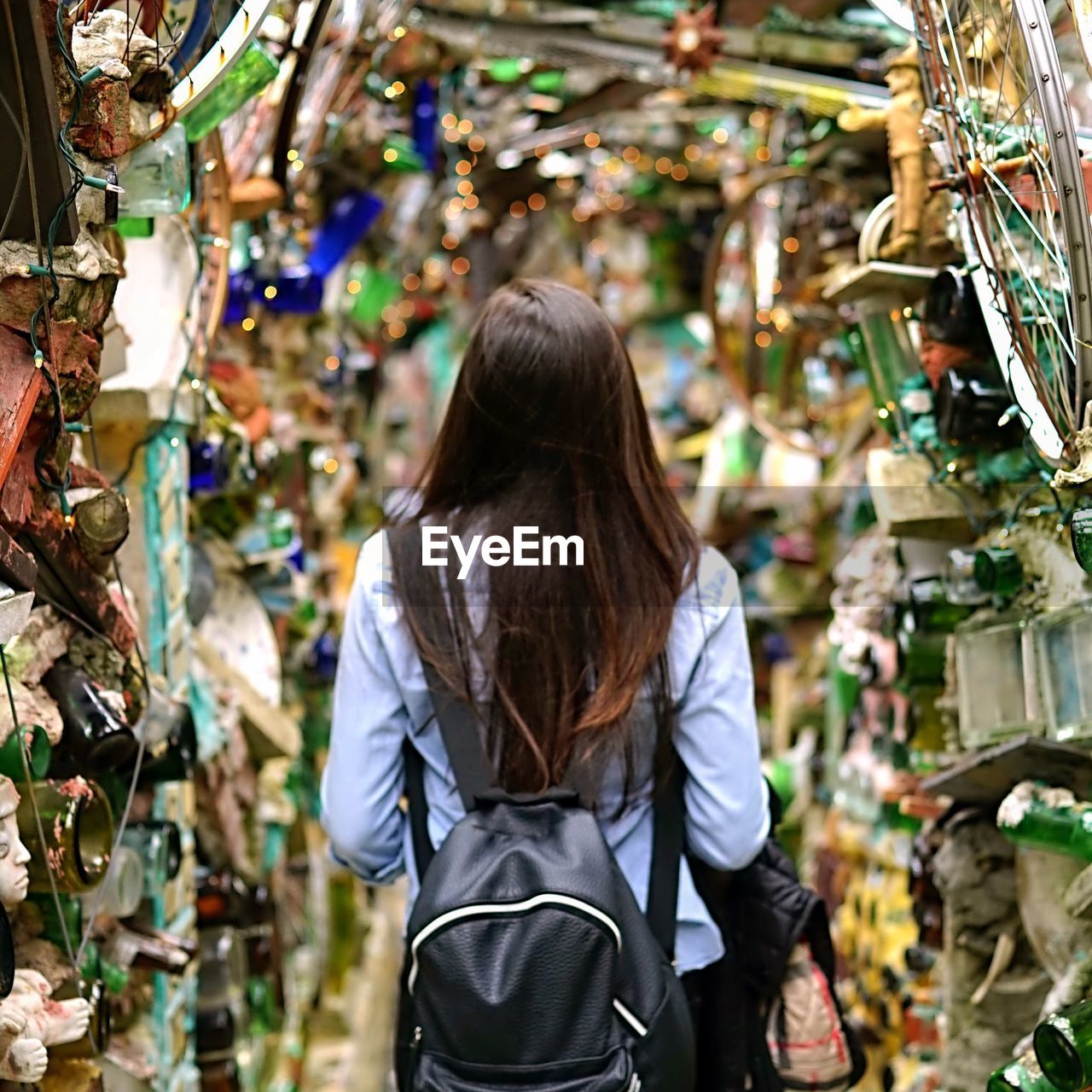 Rear view of woman with backpack standing at market stall