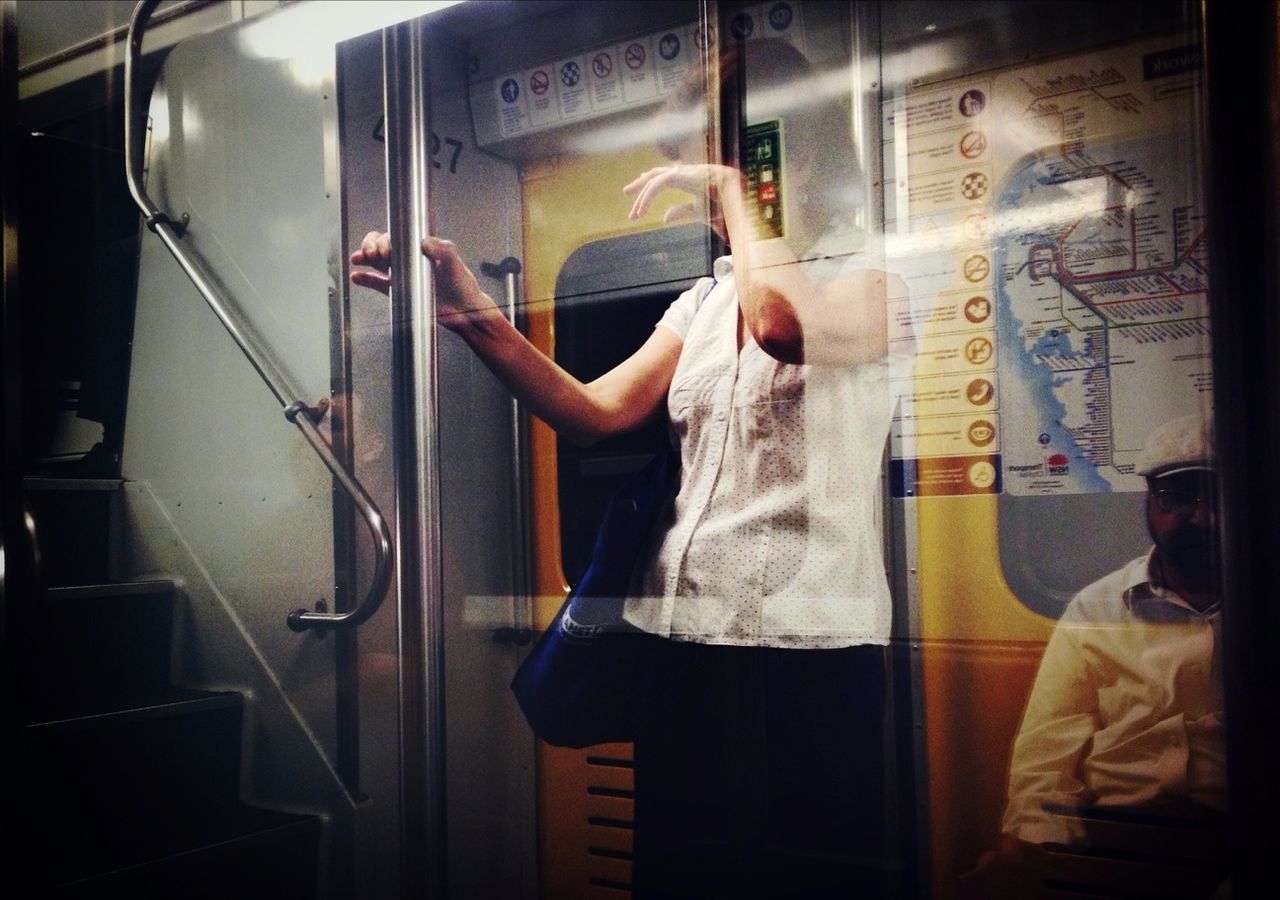 Woman and man in subway train seen from window
