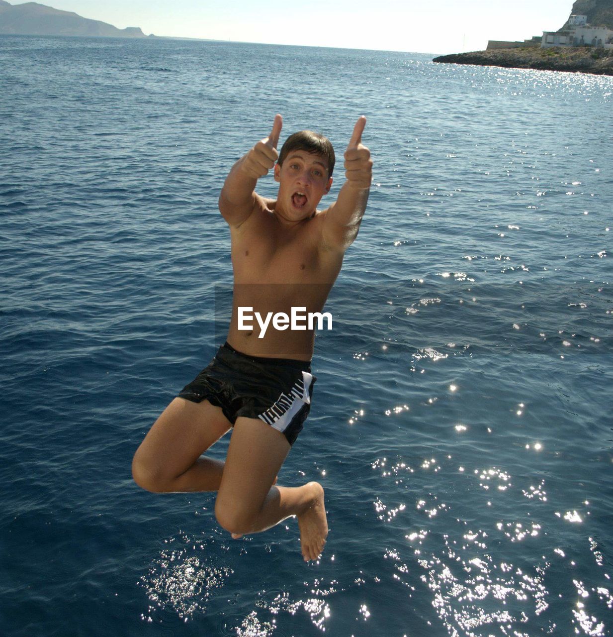 PORTRAIT OF YOUNG MAN JUMPING IN SEA