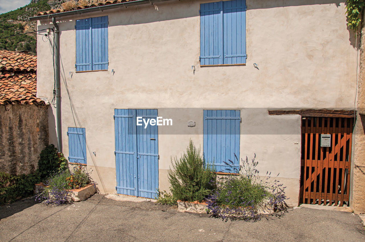 View of house with blue shutters closed at moustiers-sainte-marie, in the french provence.