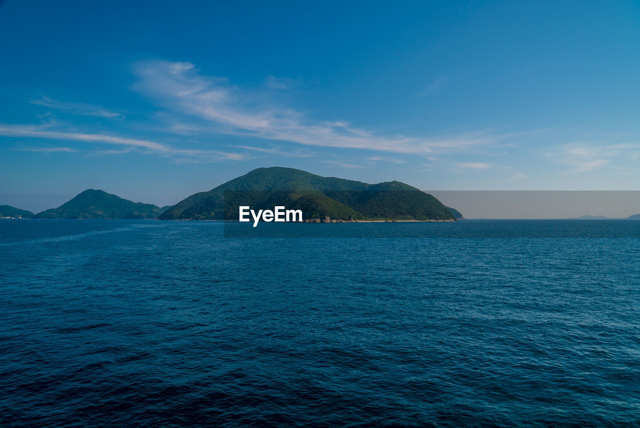 SCENIC VIEW OF SEA BY MOUNTAIN AGAINST SKY