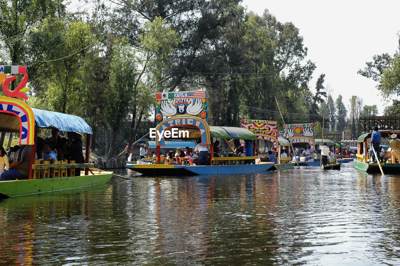 PEOPLE ON RIVER AGAINST TREES