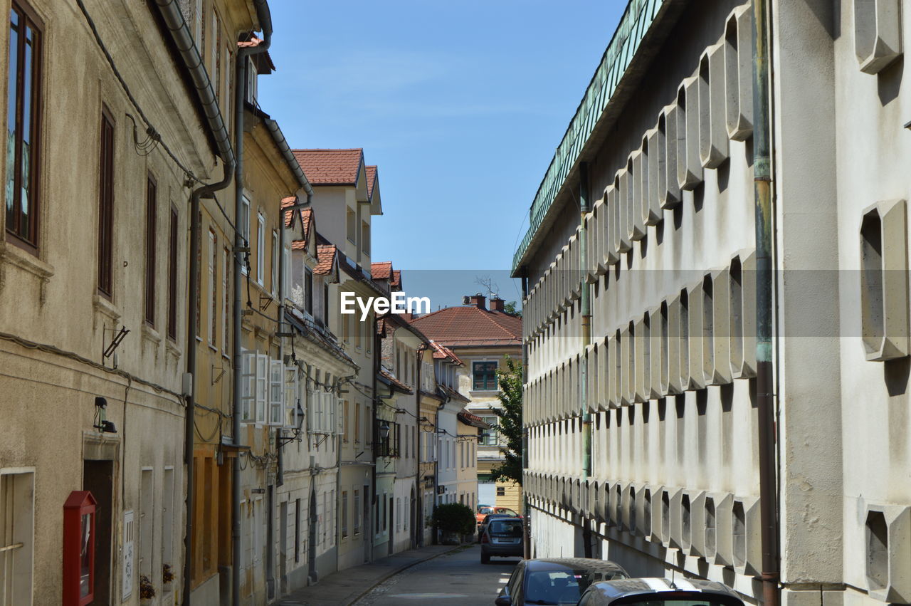 STREET AMIDST BUILDINGS AGAINST SKY