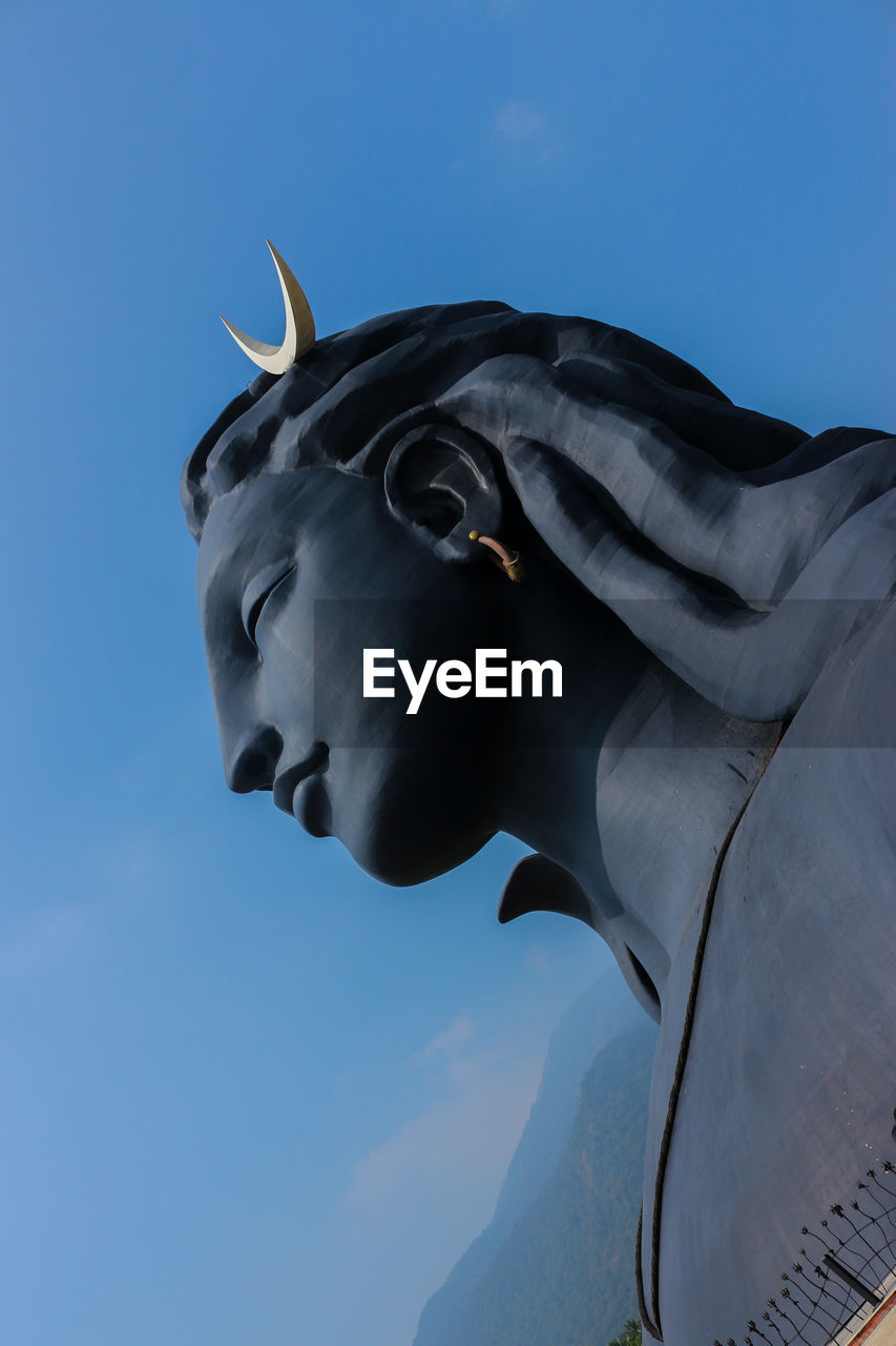 CLOSE-UP OF STATUE AGAINST BLUE SKY