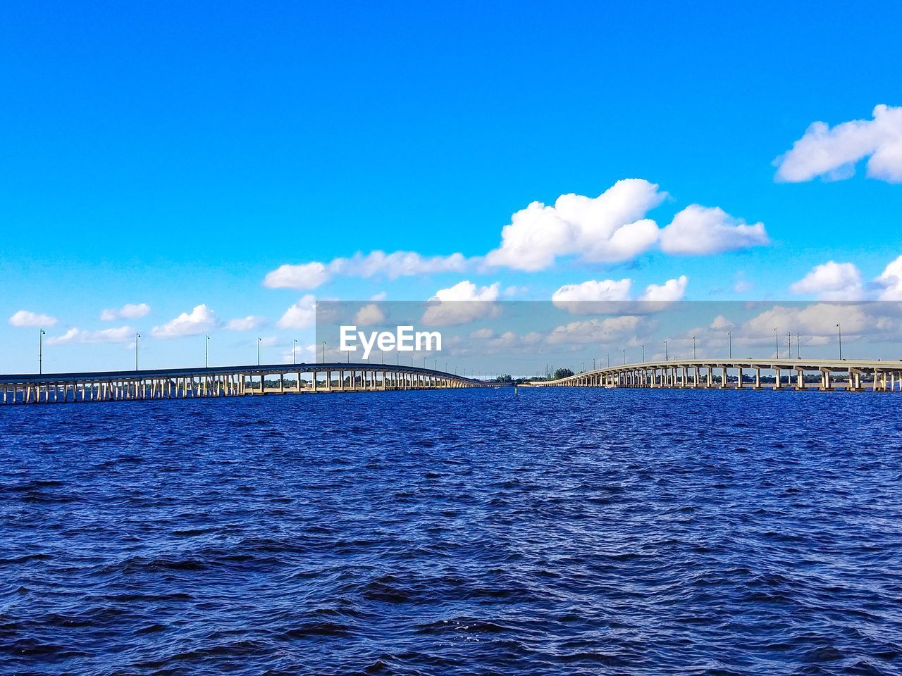 Bridge over sea against blue sky