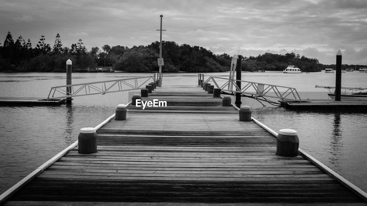 Boardwalk amidst trees against sky