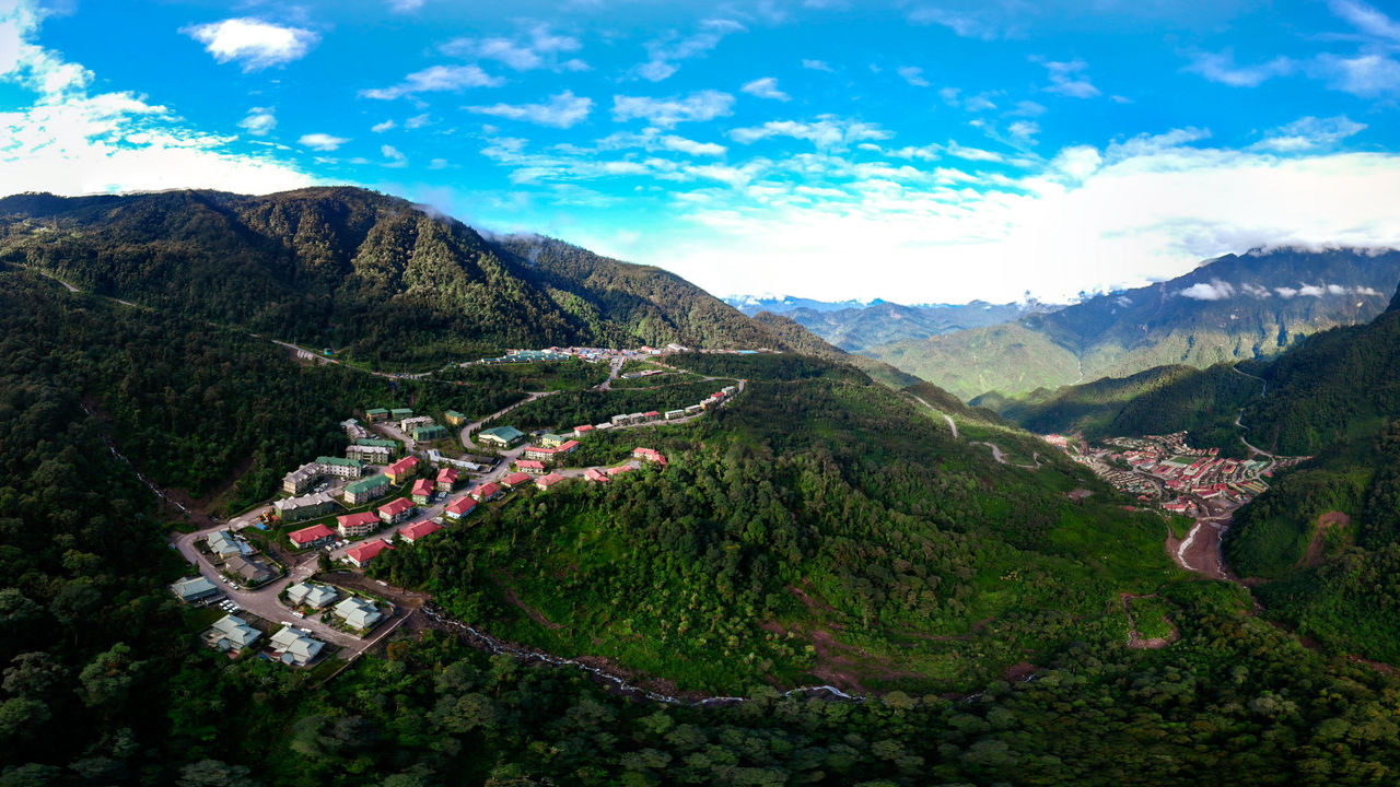 HIGH ANGLE VIEW OF TREES AND MOUNTAINS AGAINST SKY